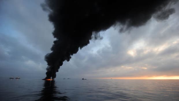 Black smoke clouds billow from a controlled burning of oil in the Gulf of Mexico, May 7, 2010. Photograph taken by Mass Communication Specialist, 2nd Class Justin Stumberg. 