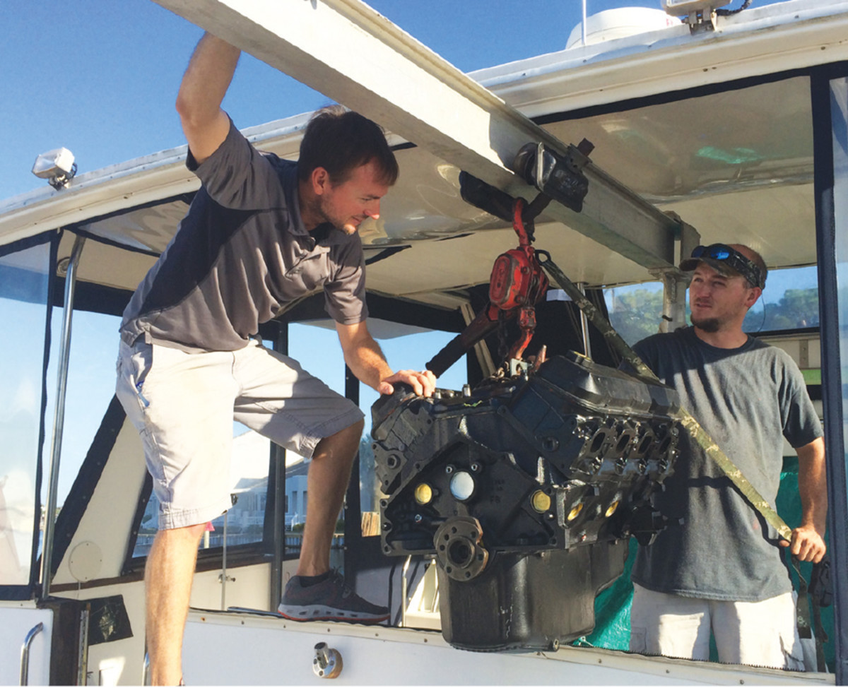 Employees of Panama City’s Gulf Coast Marine Service removing an engine.